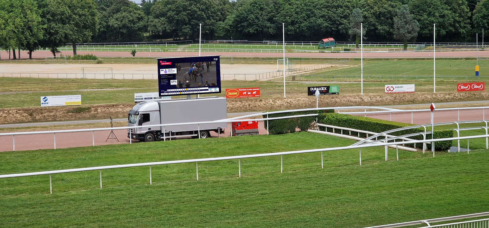 Installation d'un camion écran géant LED sur un hippodrome pour retransmission en direct.
